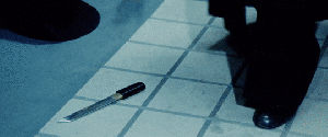 gif of Meiko Kaji in Female Prisoner #701: Scorpion, grabbing a knife off the floor and pointing it at the camera