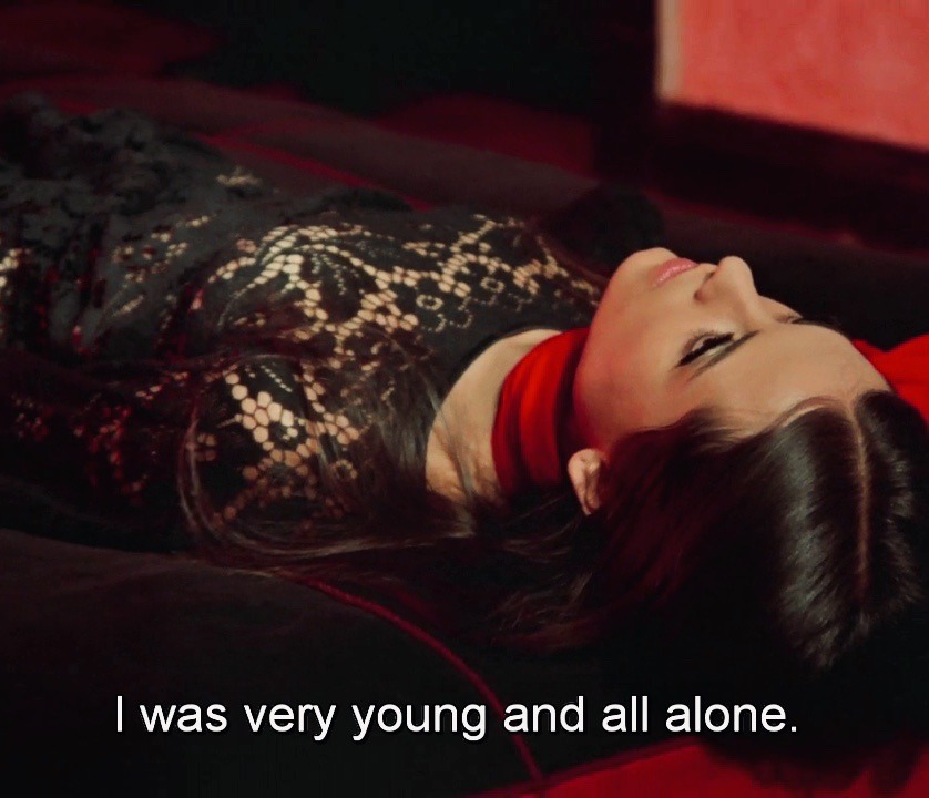 a woman lying on her back with eyes wide open. The subtitles read 'I was very young and all alone'
